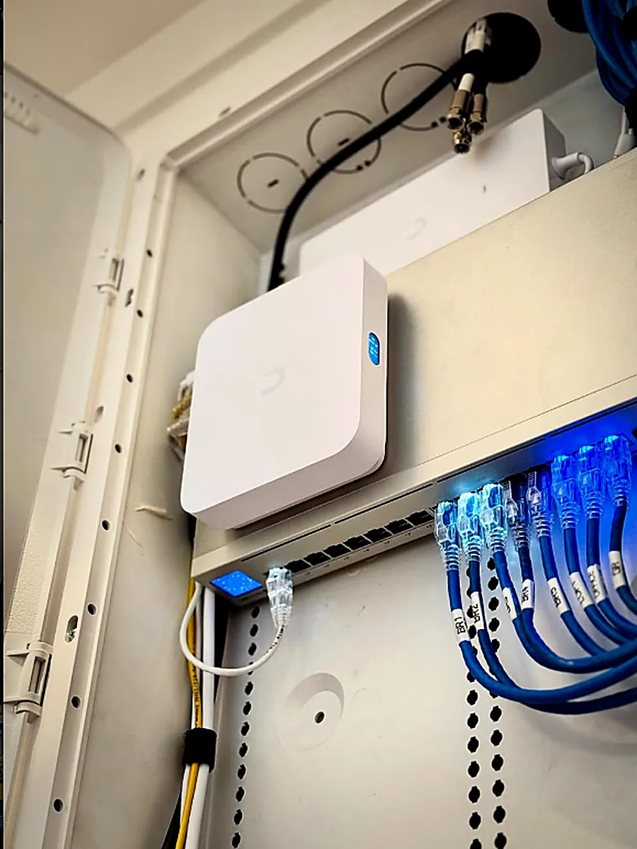 Structured wiring enclosure with a UniFi access point and labeled Cat6 patch cables