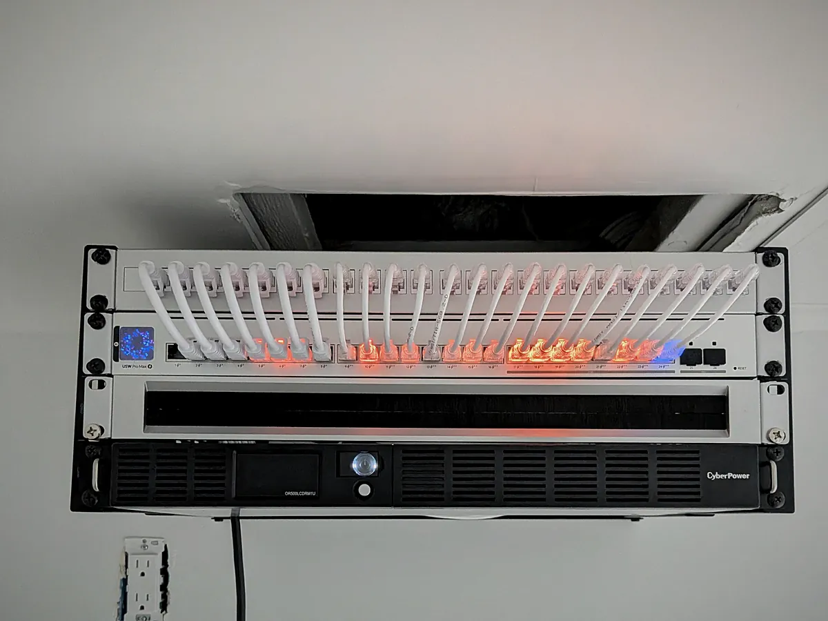 Wall-mounted network rack with patch panel and UPS after a Lynx Technology install