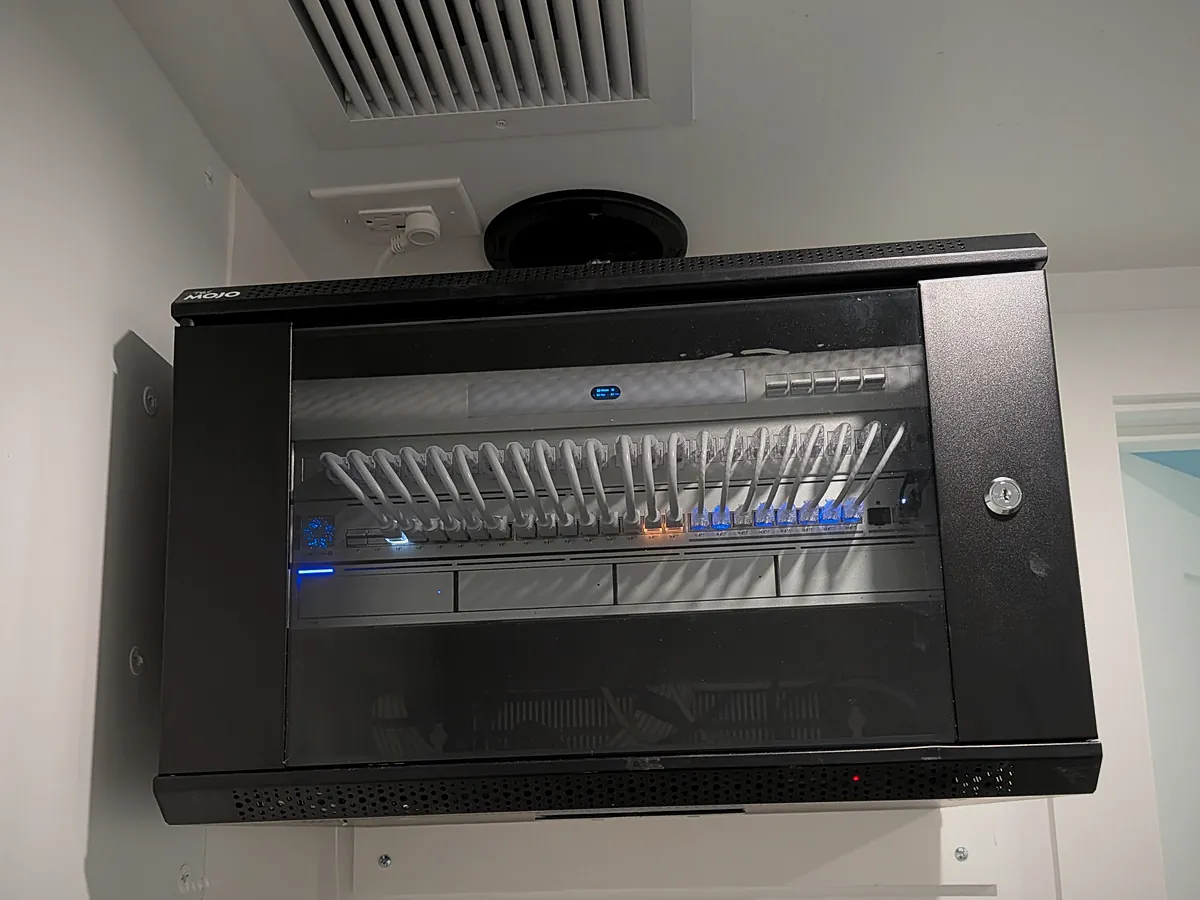 Wall-mounted network cabinet with a managed switch and labeled patch panel