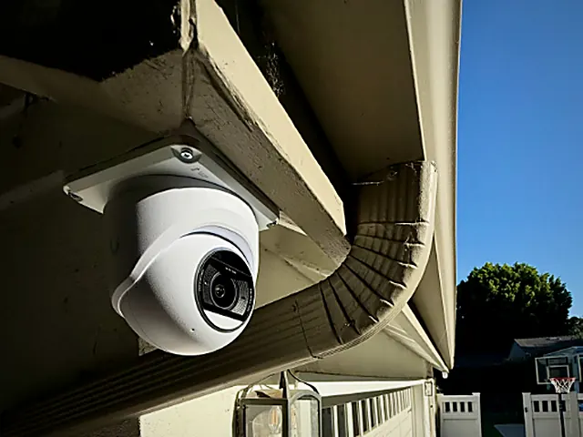 Dome surveillance camera mounted under a roof eave